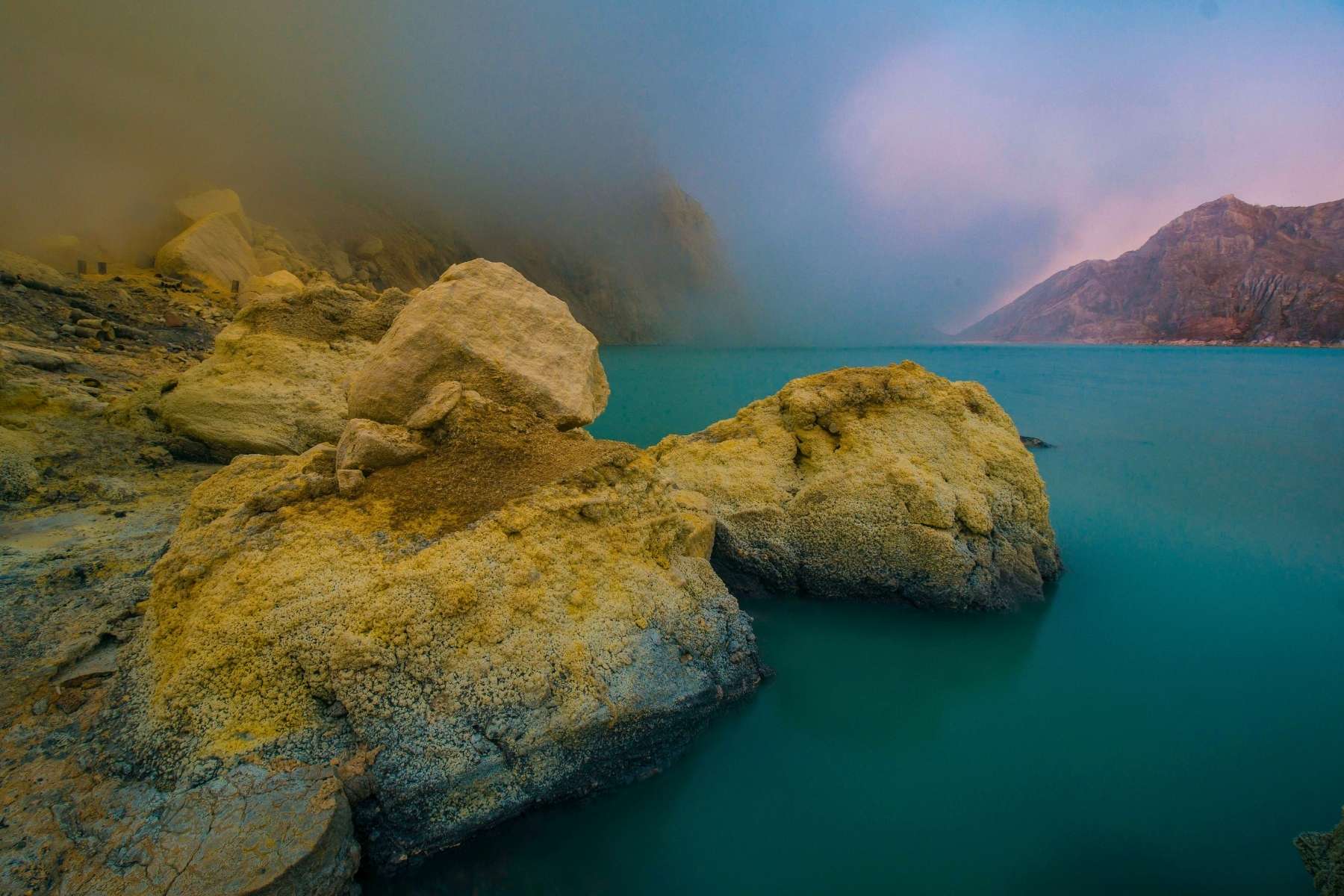 Turquoise crater lake of Mount Ijen at sunrise