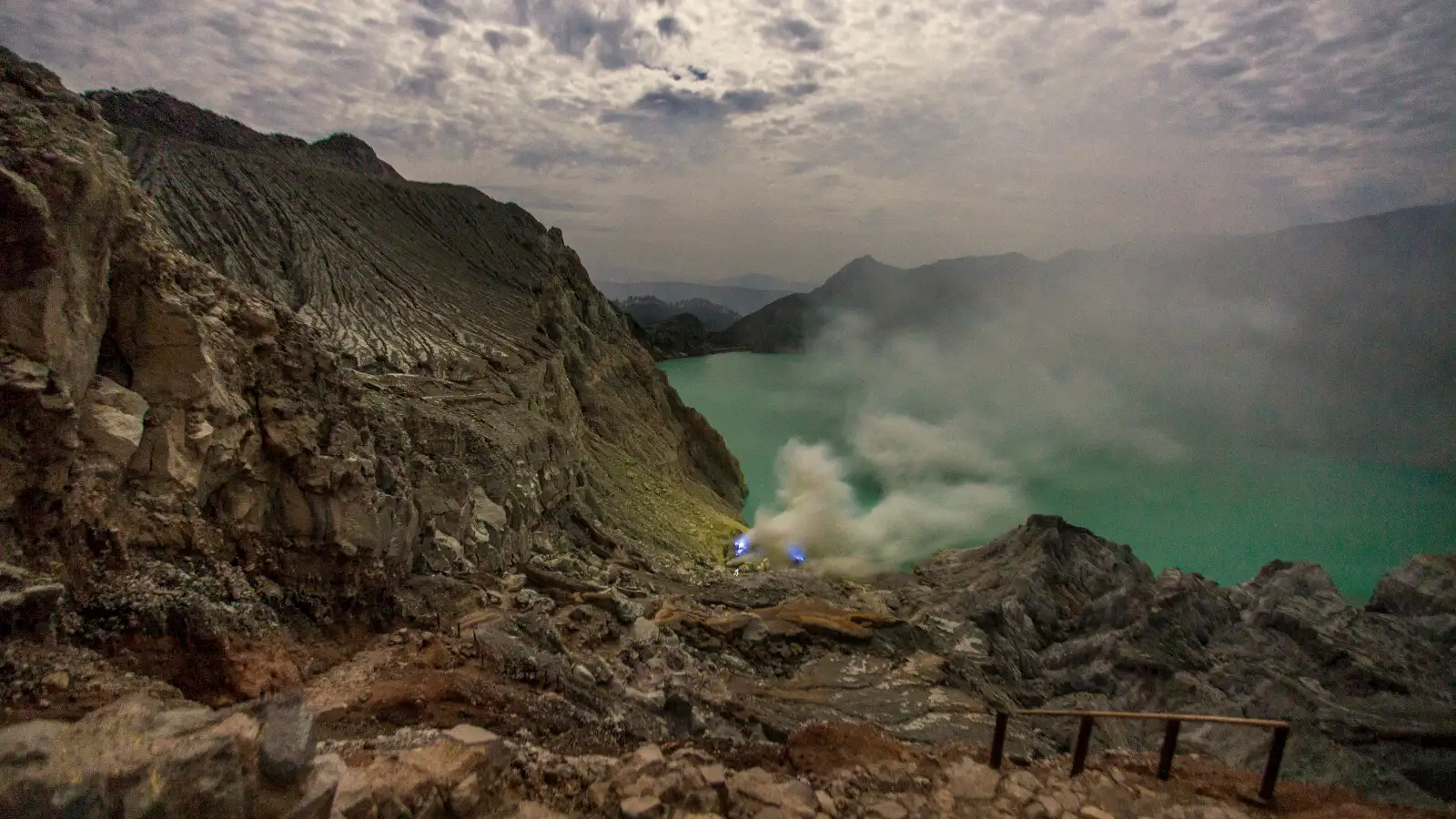 Panoramic view of the turquoise acid lake at Ijen Crater with volcanic steam
